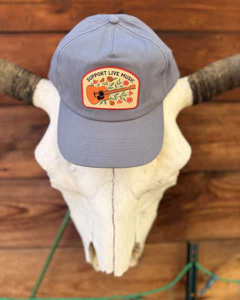 Support Live Music Hat displayed on a cow skull, featuring vibrant design and adjustable fit for everyday wear.