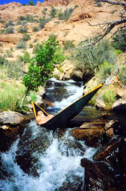 Trek Light founder Seth Haber relaxing in a hammock over a waterfall in a scenic canyon setting in 2004.