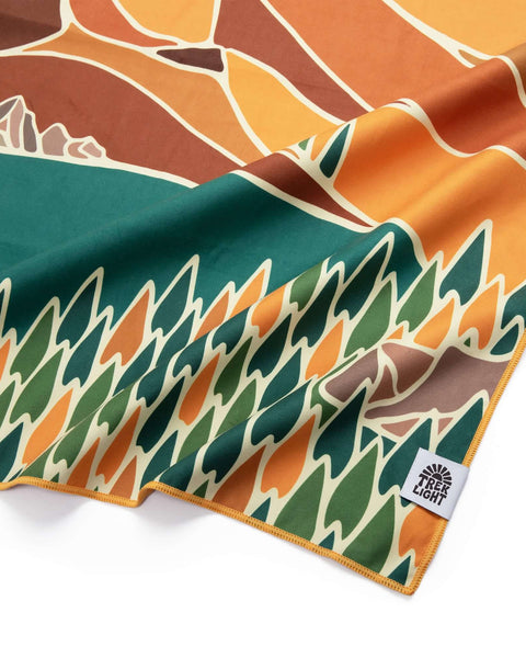 Alpenglow Wander Towel by Trek Light, made from recycled materials, featuring vibrant nature design. Lightweight, eco-friendly, quick dry.
