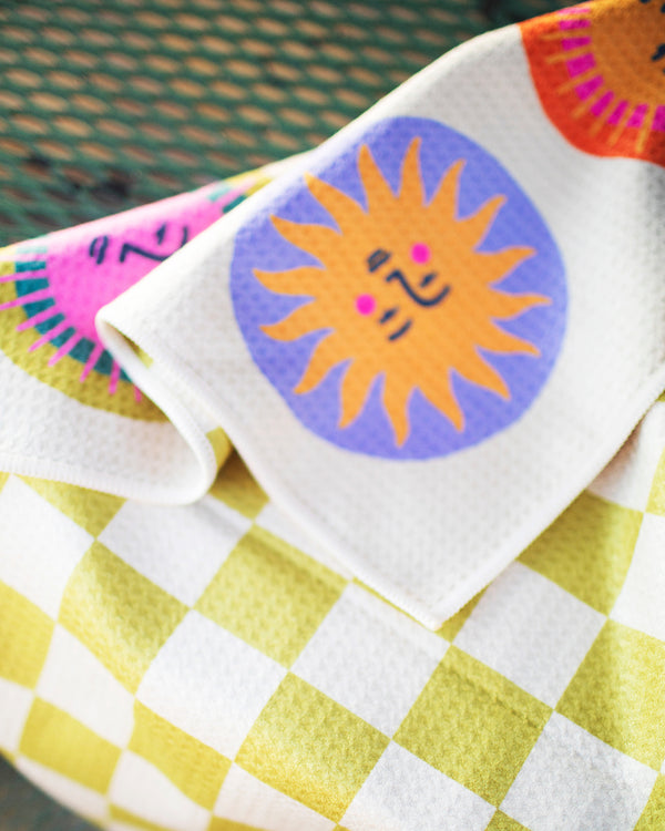 Always Sunny Kitchen & Tea Towel featuring colorful sun designs on a cheerful yellow and white checkered pattern.