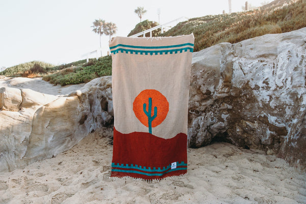 Handwoven Arizona blanket by Trek Light with cactus design and sunset colors, made from recycled clothing materials. Beautiful, cozy, versatile.