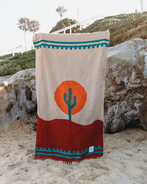 Handwoven Arizona blanket by Trek Light with cactus design and sunset colors, made from recycled clothing materials. Beautiful, cozy, versatile.