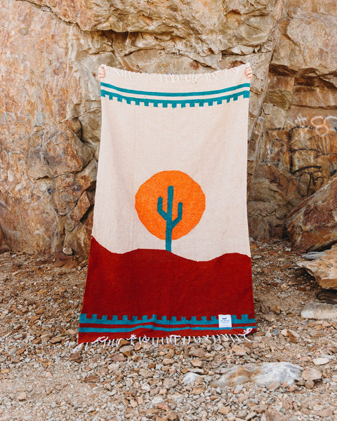 Cozy, versatile Arizona Blanket: handwoven from recycled clothing, featuring a cactus design in a beautiful desert sunset palette by Trek Light.