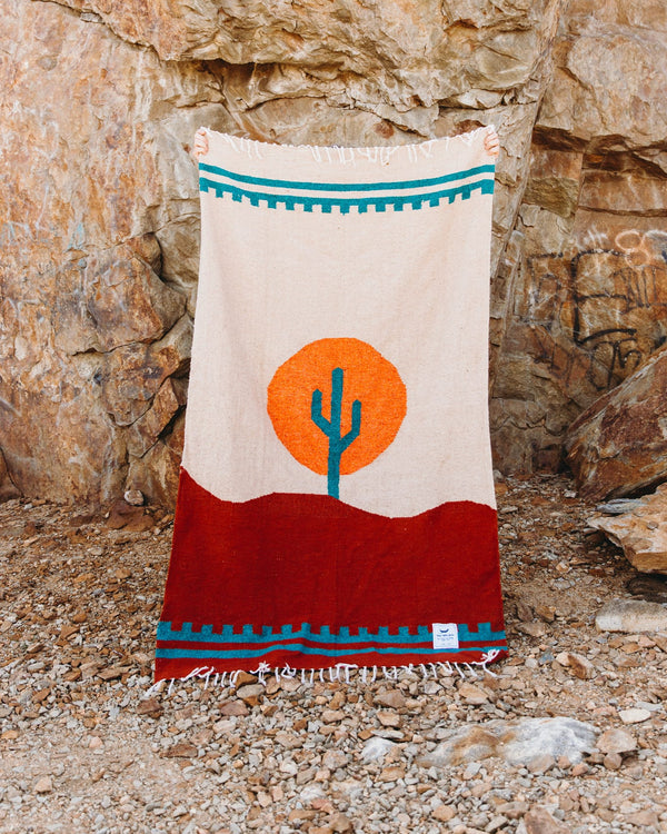 Cozy, versatile Arizona Blanket: handwoven from recycled clothing, featuring a cactus design in a beautiful desert sunset palette by Trek Light.