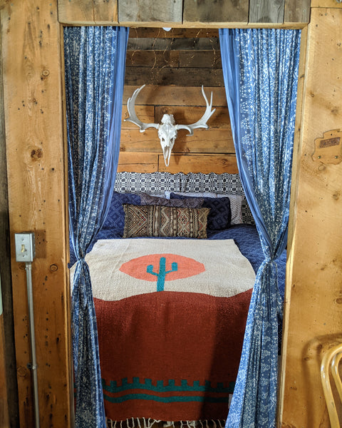 Cozy Arizona Blanket on bed with desert design and colorful patterns, enhancing rustic decor.