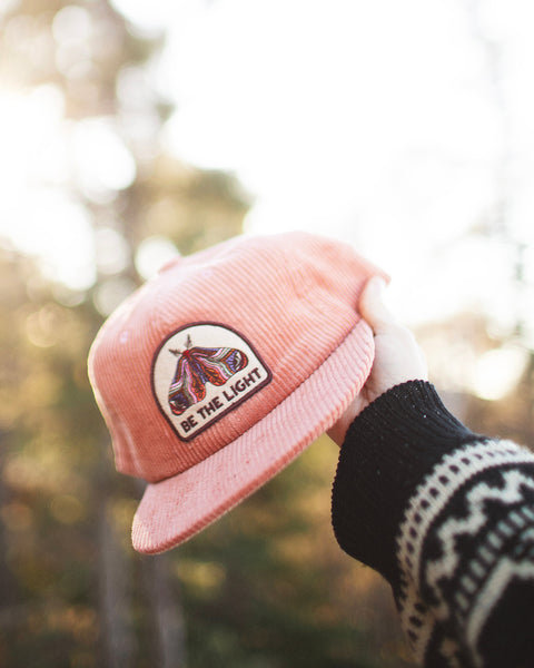 Be The Light Hat held in hand, featuring a colorful design, perfect for casual wear and outdoor activities.