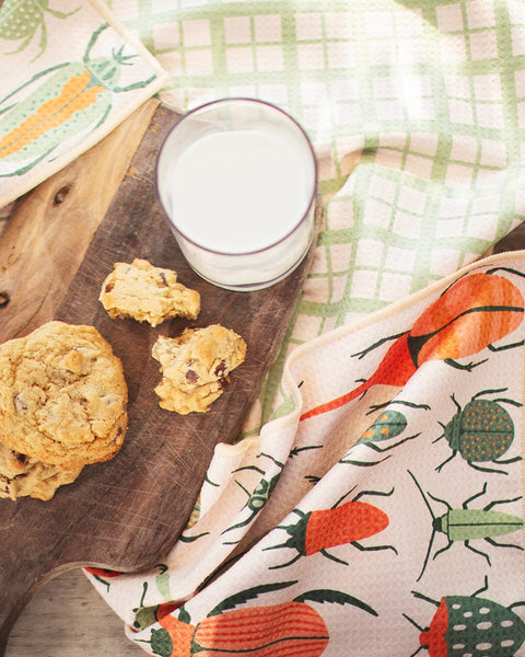 Beetlemania eco-friendly kitchen towel with beetle design, super absorbent, displayed with cookies and milk on wooden board.