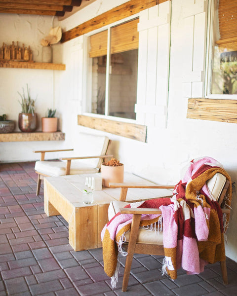 Cozy Bernie Blanket draped over a chair in a bright living space, perfect for stylish warmth and comfort.