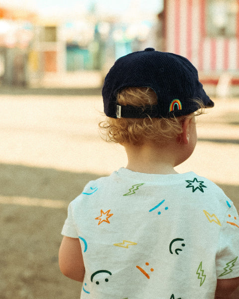 Child wearing a Big Fan Of Fun Kids Hat, enjoying a sunny day outdoors.