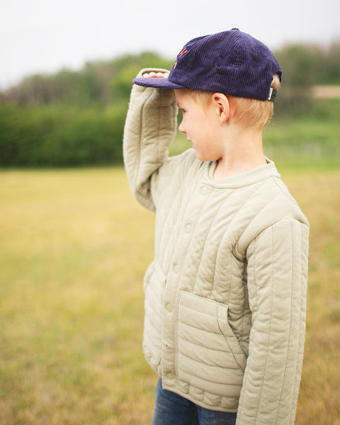 Child wearing a Big Fan Of Fun Kids Hat while standing on a grassy field, showcasing its playful design.