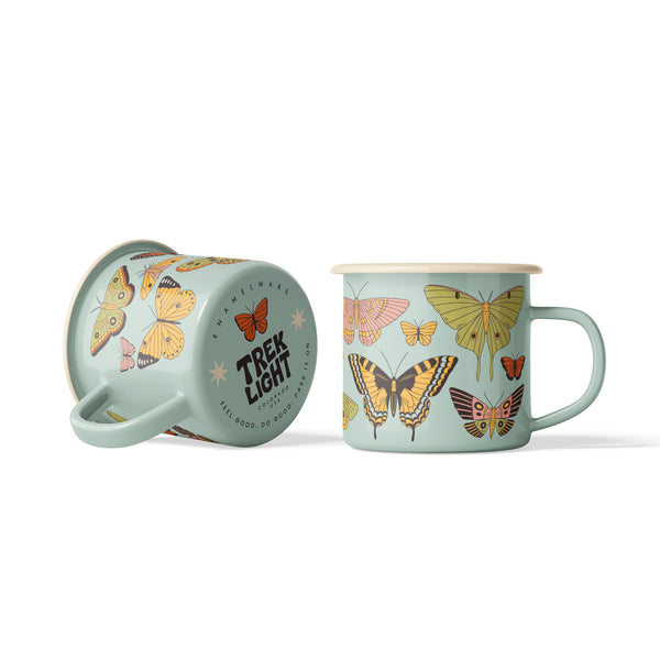 Sage green Butterfly Beauty enamel mug shown on its side next to upright mug, vintage butterfly and moth illustrations.