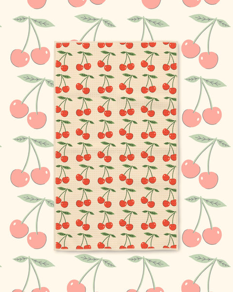 Cherry Lover Kitchen & Tea Towel with red cherries and green leaves in rows on a cream background