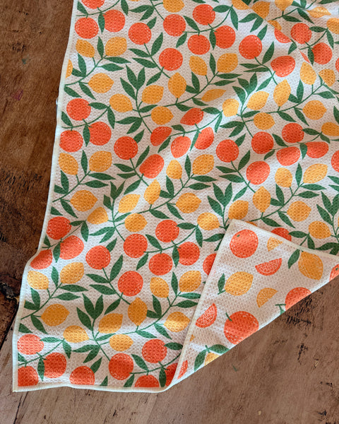 Saved By Citrus Kitchen & Tea Towel featuring vibrant citrus fruit pattern on a textured fabric.