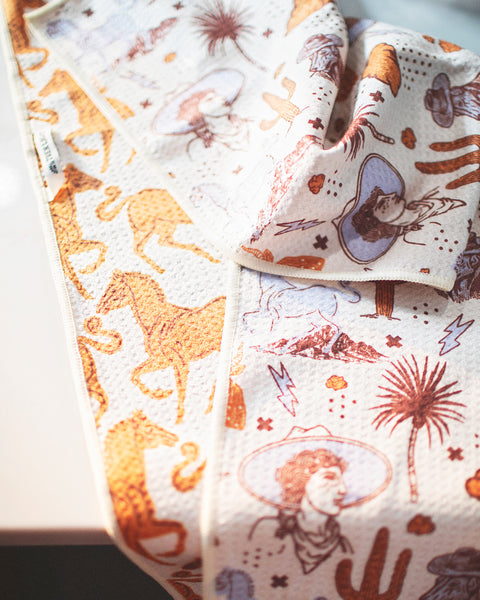 Cosmic Cowgirl Kitchen & Tea Towel featuring vibrant, double-sided designs with Western motifs.