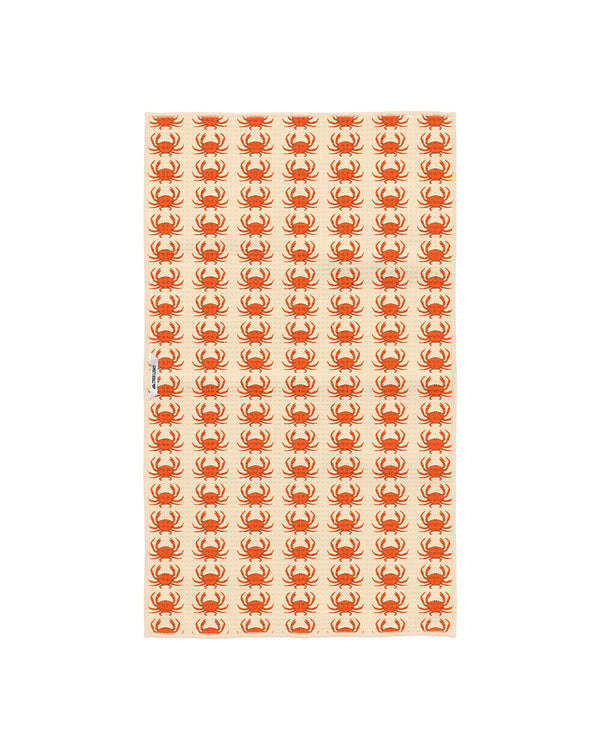 Reverse side of the crab kitchen tea towel showing smaller repeating orange crabs on cream fabric with a Trek Light woven