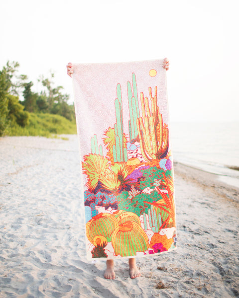 Desert Dreams Wander & Travel Towel displayed on a beach with vibrant landscape design, perfect for quick-dry needs.