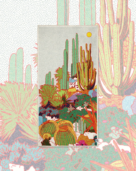 Desert Dreams Wander & Travel Towel with a colorful cactus print on cream, set over a faded pink and green cactus pattern