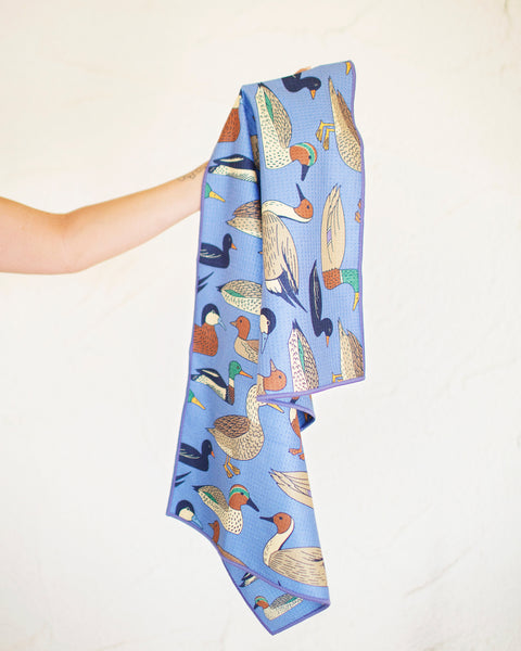 Ducks In A Row Kitchen & Tea Towel showcasing colorful duck designs on a blue fabric, perfect for kitchen use.