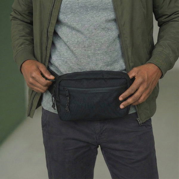 Person wearing Everyday Fanny Pack (Eclipse) with multiple zippered pockets for organized storage, shown in a casual outfit.