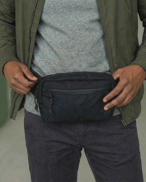 Person wearing Everyday Fanny Pack (Eclipse) with multiple zippered pockets for organized storage, shown in a casual outfit.