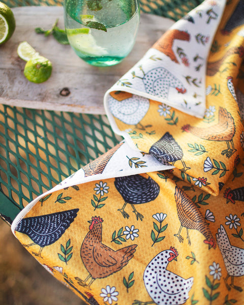 Farmhouse Chicken Kitchen & Tea Towel displayed on a green table with a refreshing drink and limes.