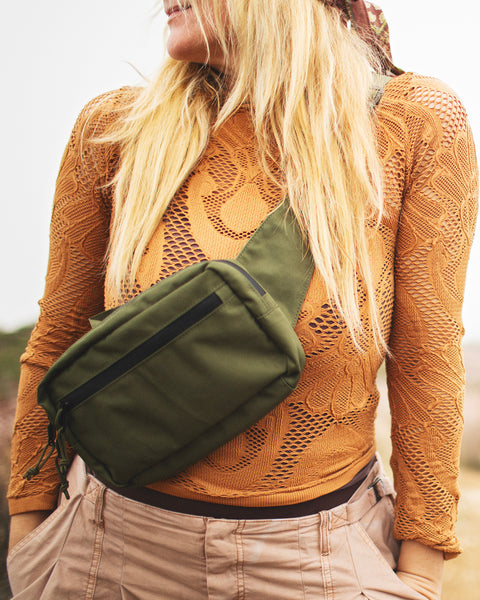 Everyday Fanny Pack (Fern) worn casually on a woman's torso, surrounded by outdoor scenery.