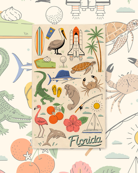 Florida Kitchen & Tea Towel with Florida icons like a flamingo, manatee, alligator, rocket and oranges on cream