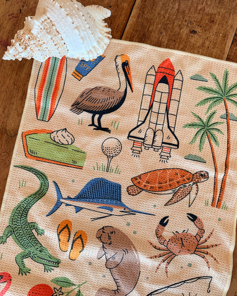 Florida Kitchen & Tea Towel featuring illustrations of Florida wildlife and beach elements, perfect for summer vibes.