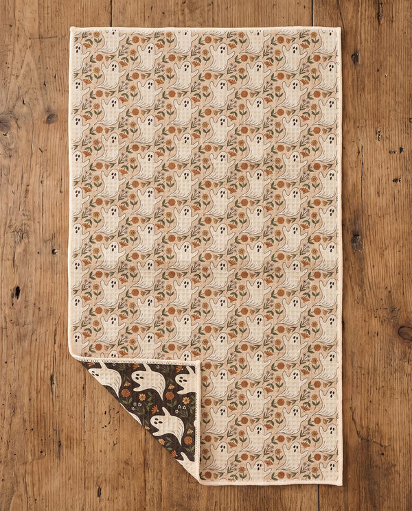 Ghost Garden kitchen tea towel flat lay with a corner folded up to reveal the dark reverse print