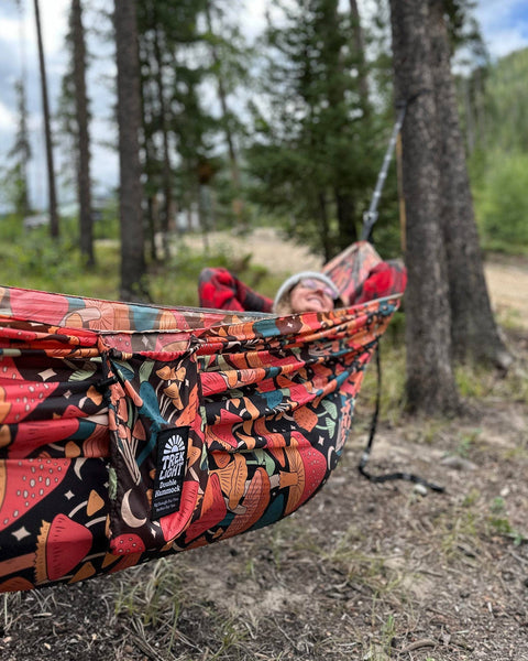 Go Anywhere Pro Hammock Straps used in a colorful hammock setup in a forest, demonstrating versatility and comfort.