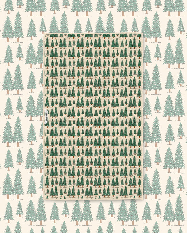 Gondola Winter tea towel laid over a matching cream ski resort pattern of mountains, gondolas, and pines