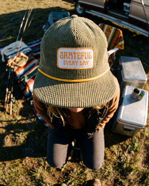 Grateful Every Day Hat displayed outdoors with mountain backdrop, emphasizing appreciation for life and casual style.