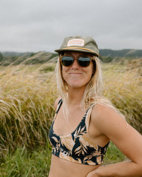 Woman in a Grateful Every Day hat enjoying a sunny day in nature, wearing Trek Light gear.