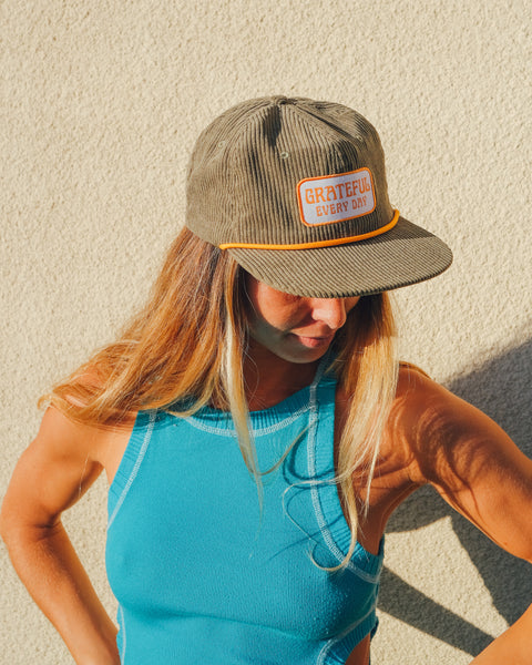 Grateful Every Day Hat on a woman with long hair, showcasing its corduroy design against a neutral background.