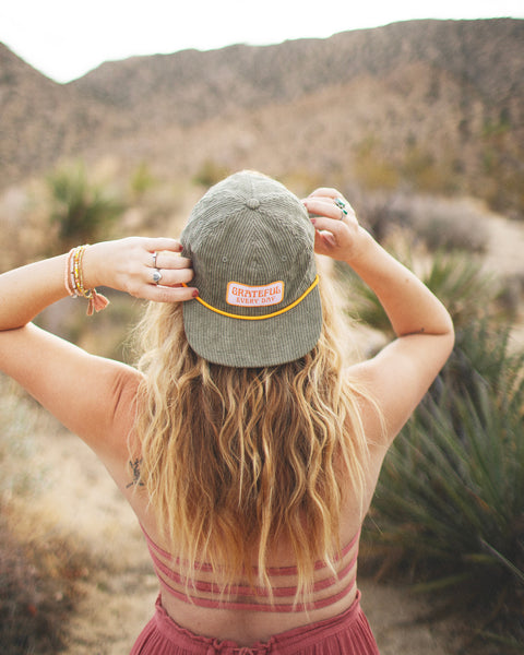 Back view of a person wearing a Grateful Every Day Hat in a desert landscape, enjoying nature.