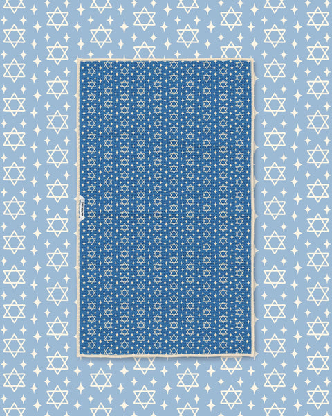 Blue Star of David kitchen towel styled flat on matching light blue star-print background