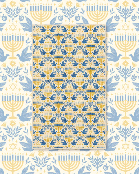 Gold and blue menorah, dove, and Star of David tea towel on cream Hanukkah-themed backdrop