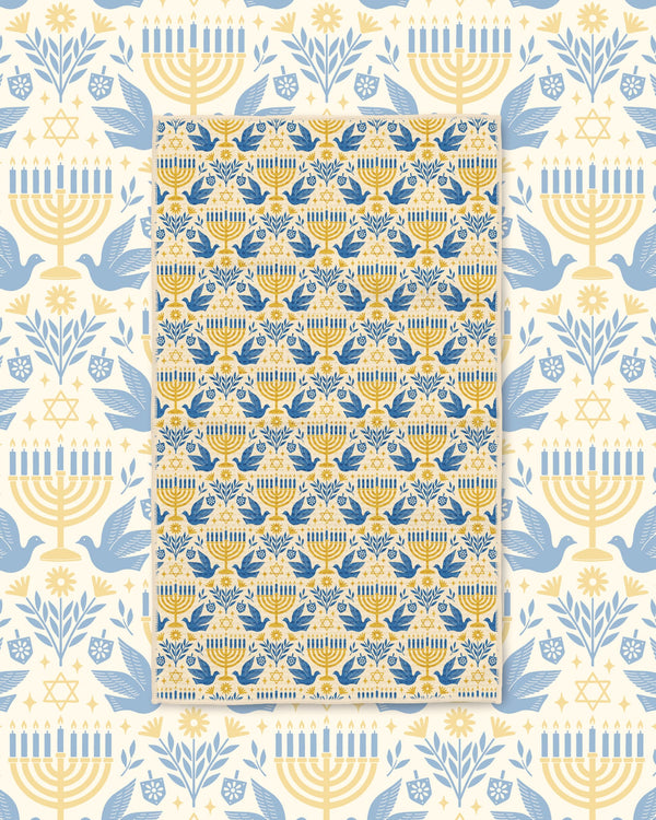 Gold and blue menorah, dove, and Star of David tea towel on cream Hanukkah-themed backdrop