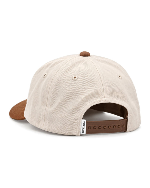 Back view of the Happy To Be Here Hat in cream twill with a brown brim, button and snap strap, on white.