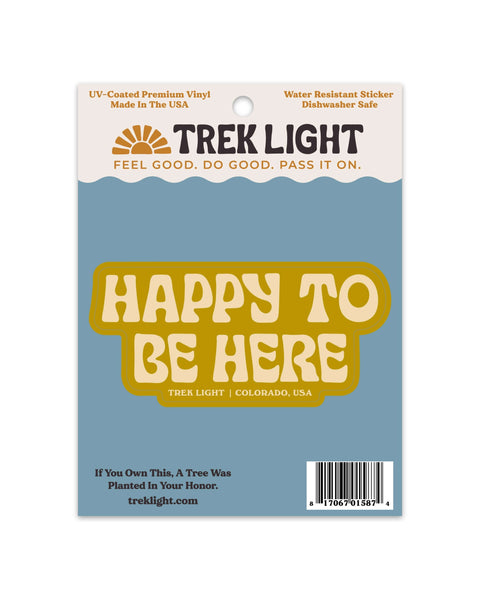 Happy To Be Here Sticker in mustard yellow and cream vinyl, on a blue backing card, shown on white.