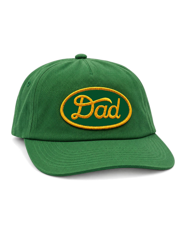 Homegrown Dad Hat in Tractor Green, a green twill cap with a gold embroidered "Dad" oval patch, on white.
