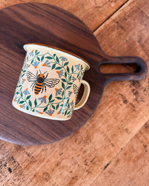 Honey Bee Enamel Mug 16oz on a wooden serving board, featuring a charming honey bee and floral design.
