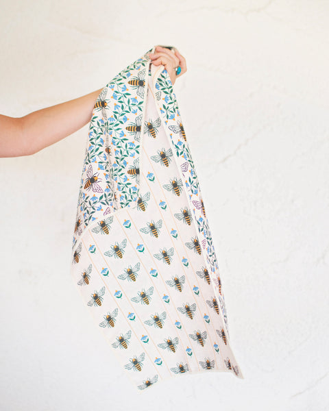 Honey Bee Kitchen & Tea Towel held up, showcasing vibrant bee patterns on eco-friendly fabric.