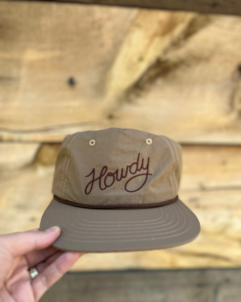 Howdy Hat in hand, featuring a stylish design with embroidered 'Howdy', perfect for festivals and everyday wear.