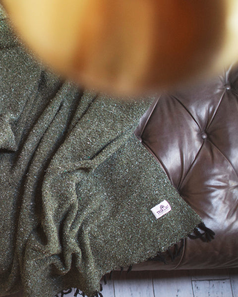 Humboldt Blanket draped on a leather couch, showcasing earthy tones and natural textures, perfect for cozy comfort.