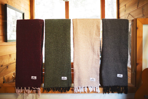 Humboldt Blanket displayed in earthy tones: burgundy, green, tan, and grey, highlighting natural textures.