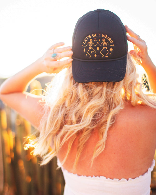 Let's Get Weird Hat showcased on a person with wavy hair, highlighting its fun design and adjustable fit.