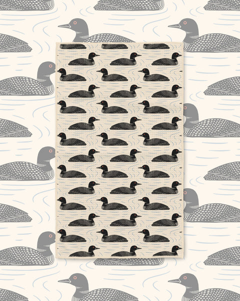 Loons Kitchen & Tea Towel with black loons swimming in rows on a cream background