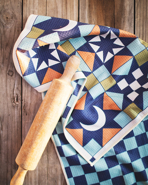 Lucky Stars Kitchen & Tea Towel displaying vibrant design with rolling pin on wooden surface.