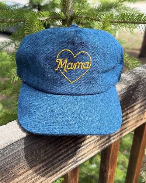 Mama Hat displayed on a wooden railing with greenery in the background, perfect gift for mothers.
